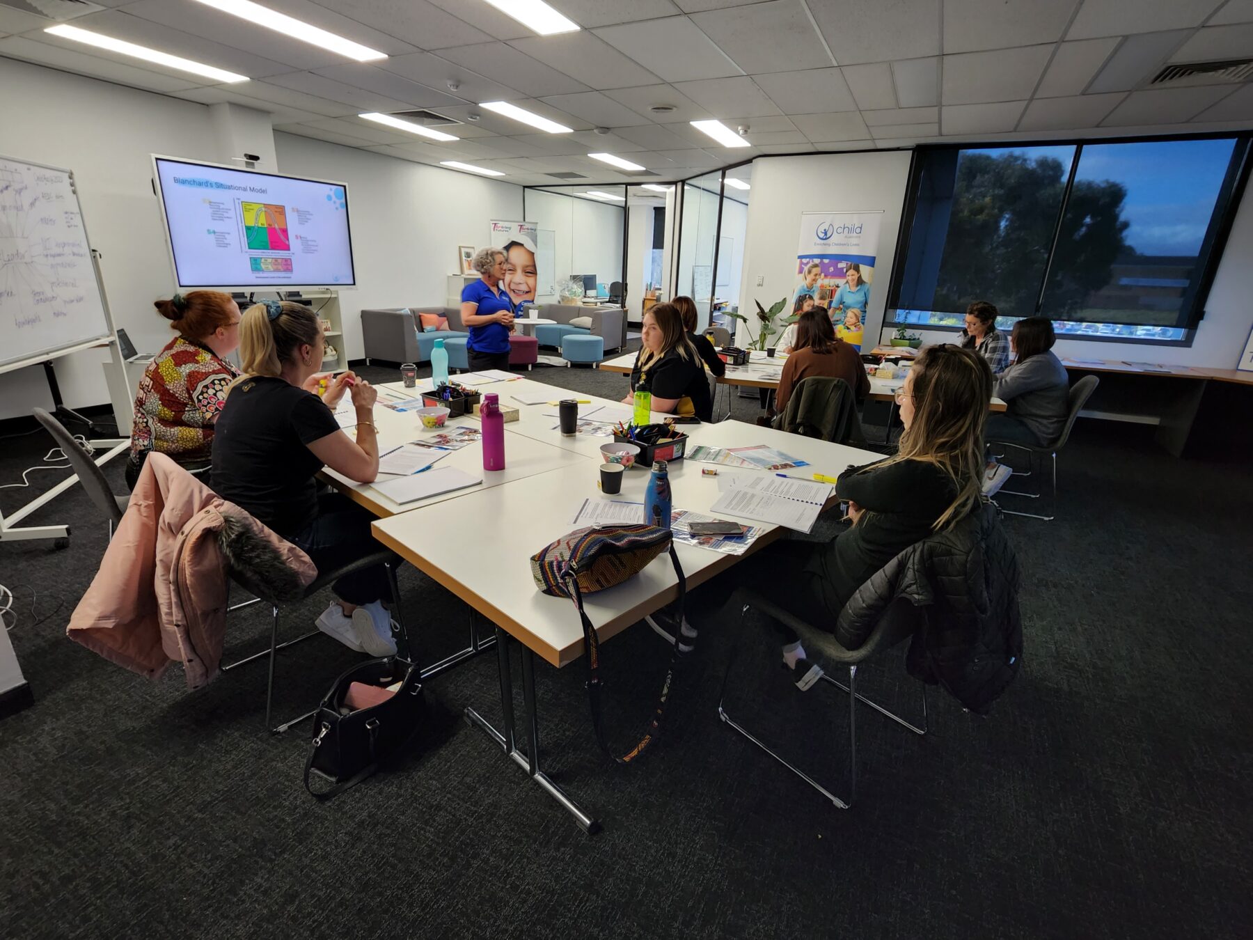 An image of Child Australia staff members sitting at a desk talking and planning
